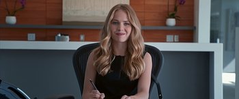 Movie still from “The Longest Ride” (2015), directed by George Tillman Jr. – A beautiful young woman sitting in a chair holding a pen; Medium shot, Low angle