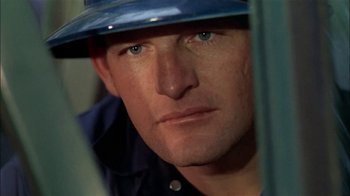Movie still from “The Longest Yard” (1974), directed by Robert Aldrich – A person wearing a hard hat; Close Up shot, High angle