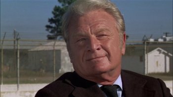 Movie still from “The Longest Yard” (1974), directed by Robert Aldrich – An older man wearing a suit and tie; Close Up shot, Low angle