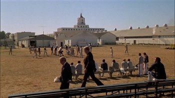 Movie still from “The Longest Yard” (1974), directed by Robert Aldrich – A group of people sitting in the grass; Extreme Wide shot, High angle