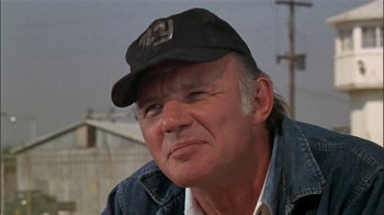 Movie still from “The Longest Yard” (1974), directed by Robert Aldrich – An older man wearing a hat and a jean jacket; Close Up shot, Low angle
