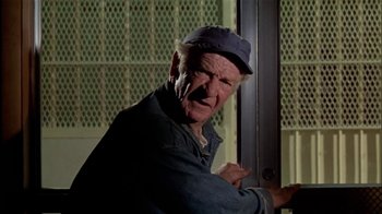 Movie still from “The Longest Yard” (1974), directed by Robert Aldrich – An older man wearing a hat and a blue shirt; Close Up shot, Low angle