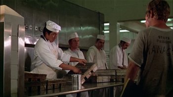 Movie still from “The Longest Yard” (1974), directed by Robert Aldrich – A group of chefs in a kitchen preparing food; Medium shot, Low angle
