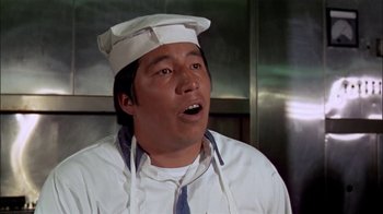 Movie still from “The Longest Yard” (1974), directed by Robert Aldrich – A man wearing a chef's hat in a kitchen; Close Up shot, Low angle