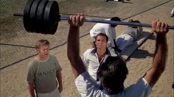 Movie still from “The Longest Yard” (1974), directed by Robert Aldrich – A group of men standing on top of a sandy beach; Medium shot, Low angle