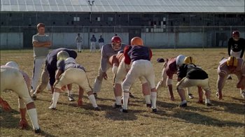 Movie still from “The Longest Yard” (1974), directed by Robert Aldrich – A group of football players are playing a game; Wide shot, High angle