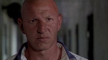 Movie still from “The Longest Yard” (1974), directed by Robert Aldrich – A man with bald head looking at the camera; Close Up shot, Low angle