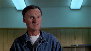Movie still from “The Longest Yard” (1974), directed by Robert Aldrich – An older man wearing a denim shirt and a white shirt; Close Up shot, Low angle