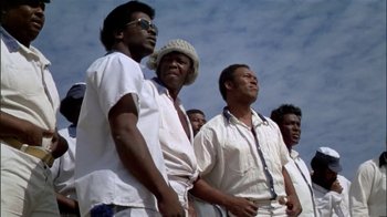 Movie still from “The Longest Yard” (1974), directed by Robert Aldrich – A group of men standing next to each other; Medium shot, Low angle