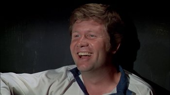 Movie still from “The Longest Yard” (1974), directed by Robert Aldrich – A person smiling with his mouth wide open; Close Up shot, Low angle