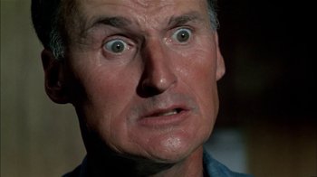 Movie still from “The Longest Yard” (1974), directed by Robert Aldrich – An older man looking surprised at the camera; Close Up shot, Low angle