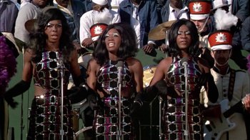 Movie still from “The Longest Yard” (1974), directed by Robert Aldrich – A group of black women singing in front of a crowd; Medium shot, Low angle