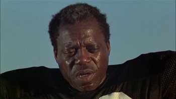 Movie still from “The Longest Yard” (1974), directed by Robert Aldrich – A person wearing a black shirt; Close Up shot, Low angle