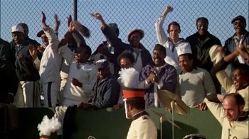 Movie still from “The Longest Yard” (1974), directed by Robert Aldrich – A group of people standing next to each other on top of a fence; Wide shot, High angle