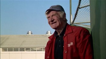 Movie still from “The Longest Yard” (1974), directed by Robert Aldrich – An older man wearing a red jacket and a hat; Close Up shot, Low angle
