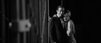 Movie still from “The Look of Love” (2013), directed by Michael Winterbottom – A man and a woman posing for a picture; Medium shot, Low angle