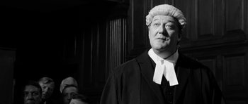 Movie still from “The Look of Love” (2013), directed by Michael Winterbottom – A man wearing a judge's wig in a court room; Close Up shot, Low angle