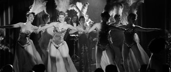 Movie still from “The Look of Love” (2013), directed by Michael Winterbottom – A black and white photo of a group of women dancing; Wide shot, Low angle