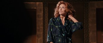 Movie still from “The Look of Love” (2013), directed by Michael Winterbottom – A woman with red curly hair wearing a black robe; Medium shot, Low angle