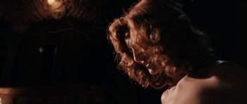 Movie still from “The Look of Love” (2013), directed by Michael Winterbottom – A person with curly red hair; Close Up shot, Low angle