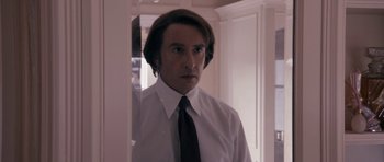 Movie still from “The Look of Love” (2013), directed by Michael Winterbottom – A man in a white dress shirt and black tie; Close Up shot, Over the shoulder angle