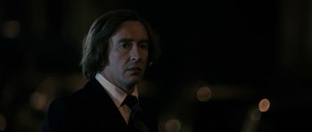 Movie still from “The Look of Love” (2013), directed by Michael Winterbottom – A person wearing a suit and tie; Close Up shot, Over the shoulder angle