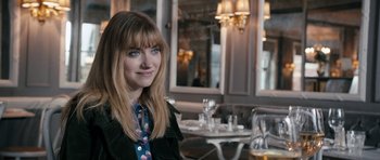 Movie still from “The Look of Love” (2013), directed by Michael Winterbottom – A woman sitting at a table with a glass of wine; Close Up shot, Over the shoulder angle