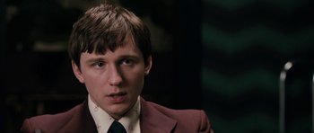 Movie still from “The Look of Love” (2013), directed by Michael Winterbottom – A man in a suit and tie looking at the camera; Close Up shot, Low angle