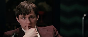 Movie still from “The Look of Love” (2013), directed by Michael Winterbottom – A man in a suit is sitting in front of a window; Close Up shot, High angle