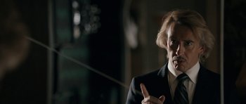 Movie still from “The Look of Love” (2013), directed by Michael Winterbottom – A man in a black suit is talking to someone; Close Up shot, Low angle