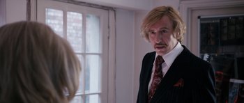 Movie still from “The Look of Love” (2013), directed by Michael Winterbottom – A man in a suit looking at himself in the mirror; Close Up shot, Over the shoulder angle