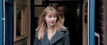 Movie still from “The Look of Love” (2013), directed by Michael Winterbottom – A woman in a coat and a man in a suit; Close Up shot, Over the shoulder angle