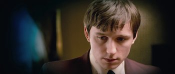 Movie still from “The Look of Love” (2013), directed by Michael Winterbottom – A man in a suit and tie looking at the camera; Close Up shot, High angle