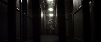 Movie still from “The Lords of Salem” (2012), directed by Rob Zombie – A woman is walking down the hall way of a building; Wide shot, Low angle