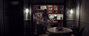 Movie still from “The Lords of Salem” (2012), directed by Rob Zombie – A woman standing in front of an open refrigerator in a kitchen; Wide shot, Low angle