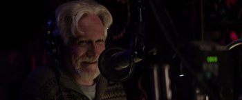 Movie still from “The Lords of Salem” (2012), directed by Rob Zombie – A man with white hair is smiling at the camera; Close Up shot, Over the shoulder angle