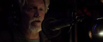 Movie still from “The Lords of Salem” (2012), directed by Rob Zombie – An older man with a beard is in front of a microphone; Close Up shot, Low angle