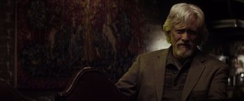Movie still from “The Lords of Salem” (2012), directed by Rob Zombie – A man in a suit sitting in a chair; Close Up shot, Low angle