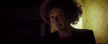 Movie still from “The Lords of Salem” (2012), directed by Rob Zombie – An older woman with curly red hair is looking at the camera; Close Up shot, Over the shoulder angle