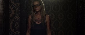 Movie still from “The Lords of Salem” (2012), directed by Rob Zombie – A woman with dreads standing in front of a wall; Medium shot, Over the shoulder angle