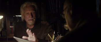 Movie still from “The Lords of Salem” (2012), directed by Rob Zombie – A man sitting in front of a man holding a bunch of pencils; Close Up shot, Over the shoulder angle