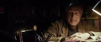 Movie still from “The Lords of Salem” (2012), directed by Rob Zombie – An older man sitting at a table with a bunch of scissors; Close Up shot, Low angle