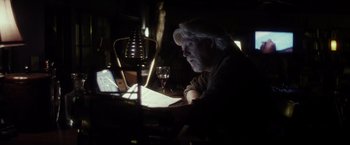 Movie still from “The Lords of Salem” (2012), directed by Rob Zombie – A man sitting at a table with a glass of wine; Medium shot, Low angle