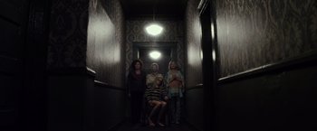 Movie still from “The Lords of Salem” (2012), directed by Rob Zombie – A group of people standing in a hallway; Wide shot, High angle