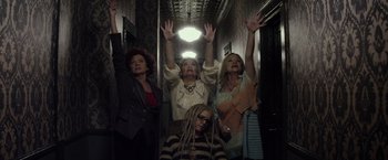 Movie still from “The Lords of Salem” (2012), directed by Rob Zombie – A group of people standing in a hallway with their hands in the air; Medium shot, Low angle