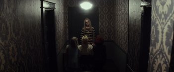 Movie still from “The Lords of Salem” (2012), directed by Rob Zombie – A group of people sitting in a room with a light shining on them; Wide shot, Low angle