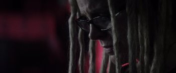 Movie still from “The Lords of Salem” (2012), directed by Rob Zombie – A man with dreads and glasses looking down; Extreme Close Up shot, Over the shoulder angle