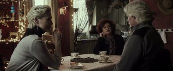 Movie still from “The Lords of Salem” (2012), directed by Rob Zombie – A group of people sitting at a table with cups; Medium shot, Over the shoulder angle