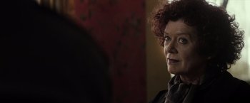 Movie still from “The Lords of Salem” (2012), directed by Rob Zombie – An older woman with red curly hair looking at the camera; Close Up shot, Over the shoulder angle