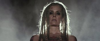 Movie still from “The Lords of Salem” (2012), directed by Rob Zombie – A woman with dreads and tattoos is looking at the camera; Close Up shot, Low angle